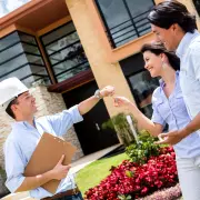 Architect handling keys to a couple